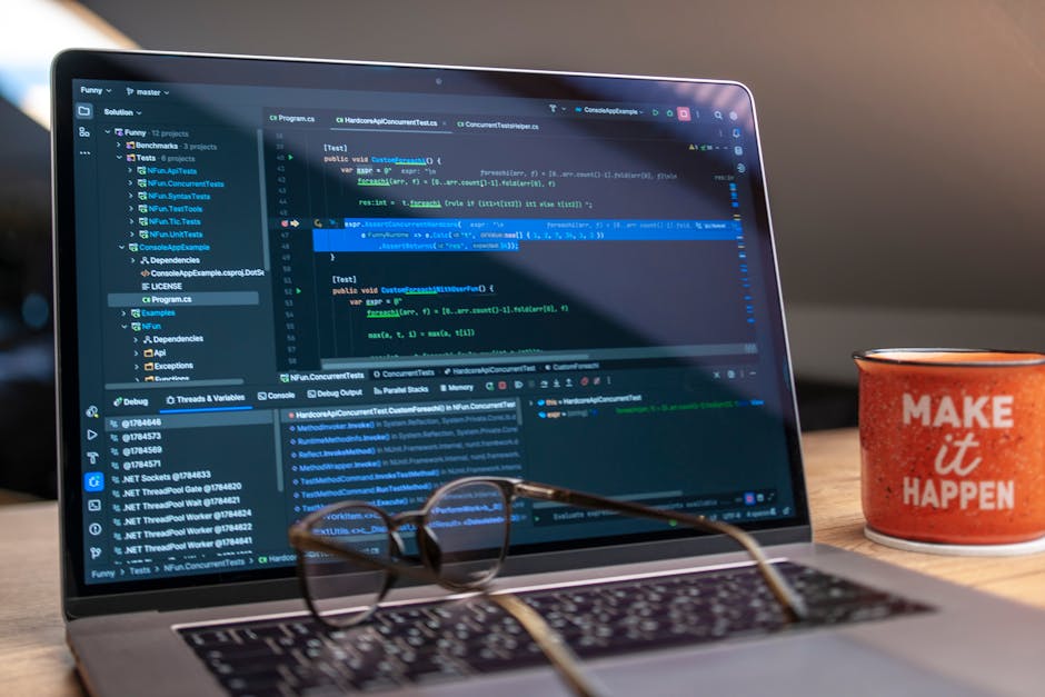 web development news May 2026 - A laptop displaying code editor with a motivational mug that reads 'Make It Happen' on a workspace.